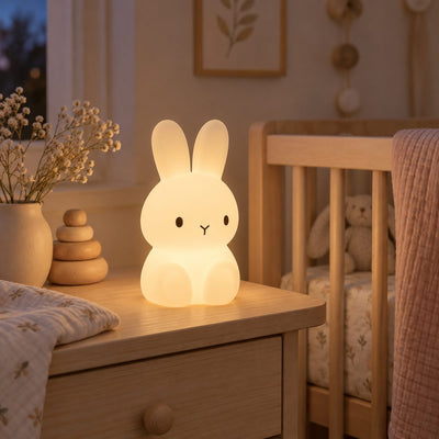 Veilleuse bébé lapin en silicone allumée sur une table de nuit