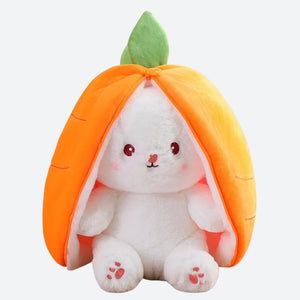 peluche lapin carotte blanc et orage posée sur une table en bois, en fond on peut voir des tiroir en bois sur la gauche et une plante sur la droite