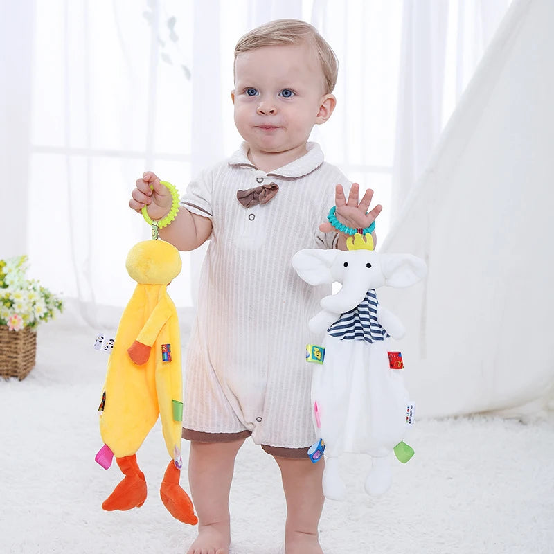 Doudou Éléphant blanc avec étiquettes et anneau sur la tête avec un enfant jouant avec lui et un doudou canard jaune