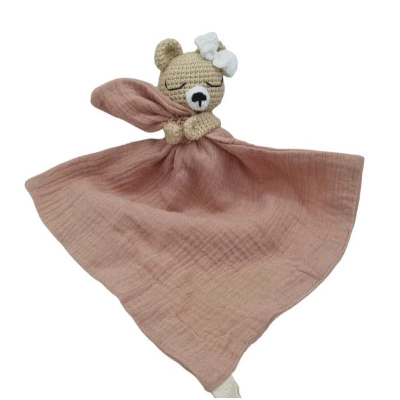 FATIMA est un adorable doudou plat représentant un ours au crochet. Doté d'un noeud blanc sur la tête, il tient un mouchoir ou carré de gaze de coton entre ses pattes pour offrir douceur et réconfort à votre enfant. Disponible en quatre coloris : Écru, Marron, Bleu et Vieux rose. ROSE