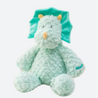 peluche dinosaure bleu posé sur un tissu blanc avec une carte aux motifs floraux à coté