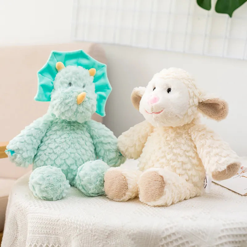 peluche mouton claire et dinosaure bleu mis en scène sur un tissu blanc