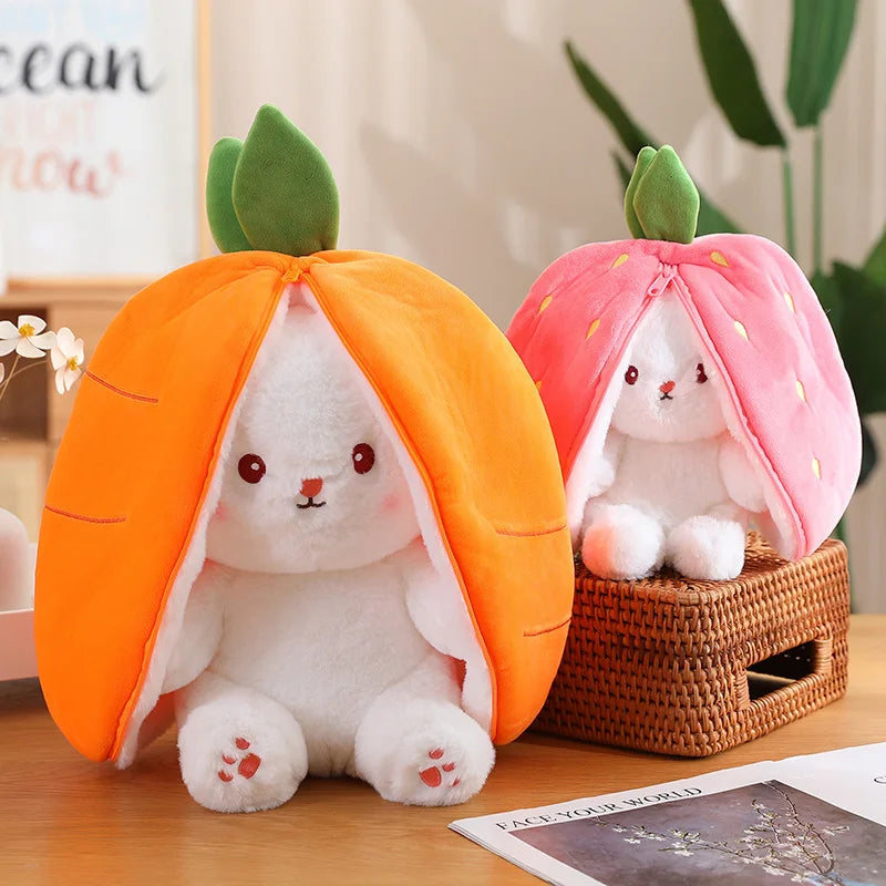 une peluche lapin carotte est posée sur une table en bois, et à droite  une peluche lapin fraise  posée sur un panier en rotin . Derrière à gauche un tableau blanc avec écriture et derrière à droite une plante verte  