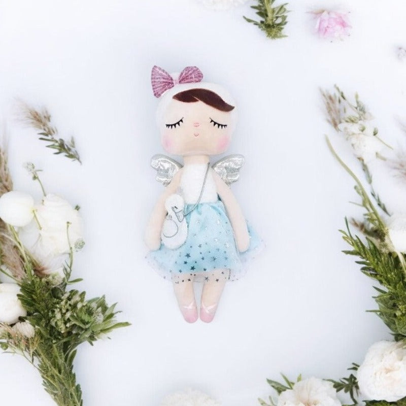 CAROLINE, la fée dolls brune, est une compagne féerique au charme envoûtant. Avec son bonnet blanc et son sac en bandoulière, ses ailes argentées dans le dos et sa robe bleue ornée de tulle et d'étoiles, elle évoque la magie et l'élégance. Parfaite pour des aventures enchantées et des moments de tendresse.