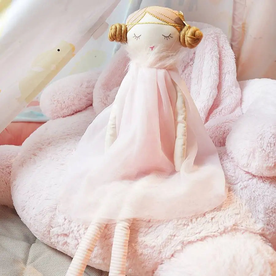 LIYA est une poupée fée de 50 cm, vêtue d'une robe volante et d'un tutu rose. Ses deux chignons tressés et ses bijoux de cheveux ajoutent une élégance supplémentaire à son apparence.