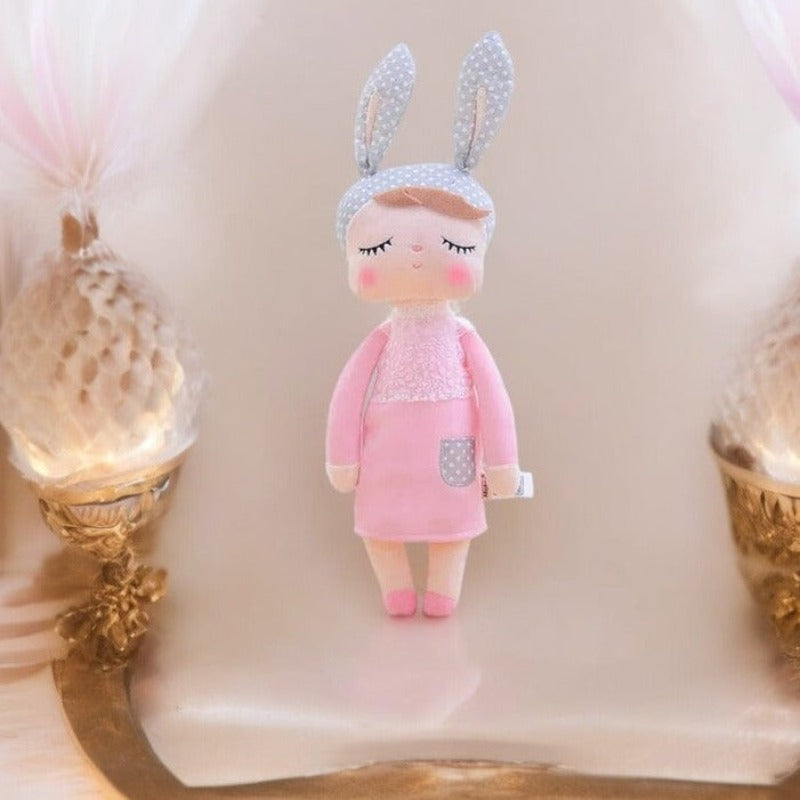 MELINA, le doudou fée Dolls, est une compagne enchantée de 34 cm conçue pour émerveiller votre enfant. Avec sa robe rose et ses oreilles de lapin grises à pois blancs, cette adorable fée devient rapidement le meilleur ami de votre petit(e), lui offrant confort et enchantement tout au long de la journée. Image