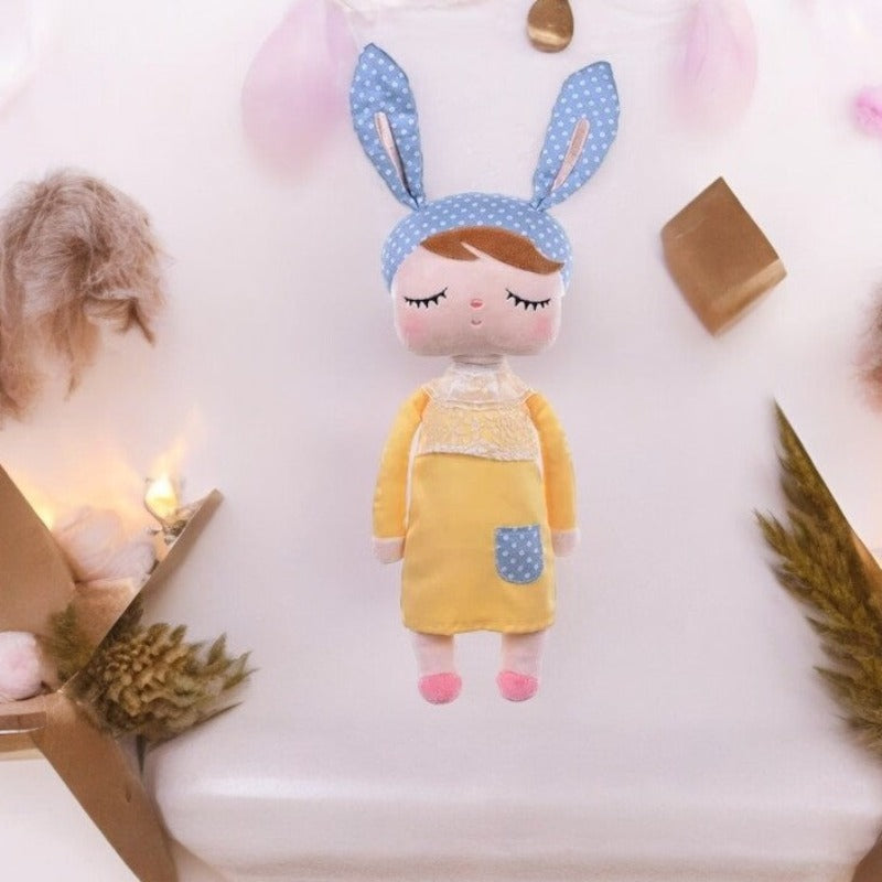 ZOEY, le doudou fée Dolls de 34 cm, est une compagne magique qui égayera les journées de votre enfant. Avec ses oreilles de lapin bleu et rose à pois, sa robe jaune et ses ballerines roses assorties, cette adorable fée deviendra rapidement le compagnon préféré de votre petit(e), lui offrant réconfort et enchantement.