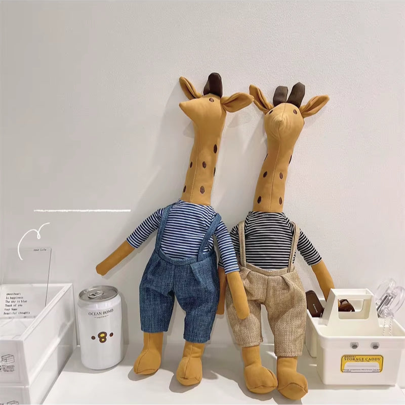 Doudou girafe habillée posée dans un décor