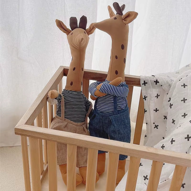 Doudou girafe habillée posée dans un landau pour bébé