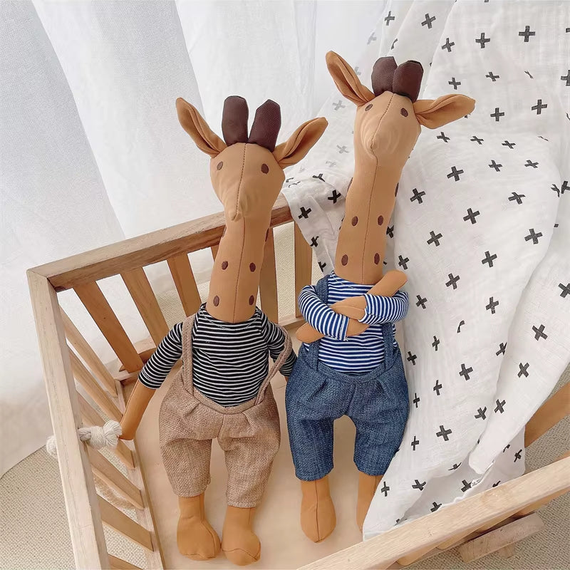 Doudou girafe habillée posé dans un landau de bébé