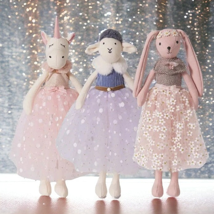 doudou peluche licorne fée en robe à rond brillant avec ceinture de satin rose avec noeud, haud côtelé rose avec fourrure rose en col, doudou peluche mouton en robe de fée blanche en tulle avec des rond brillant dessus, une ceinture marron à boucle perle blanche et haut bleu côtelé avec col en fourure blanche et un bonnet gris foncé tricoté. Doudou lapin robe à fleurs blanche, ceinture de satin nouée à la taille, haut de laine marron et blanche avec petite broche bijou et une couronne de fleurs sur la tête