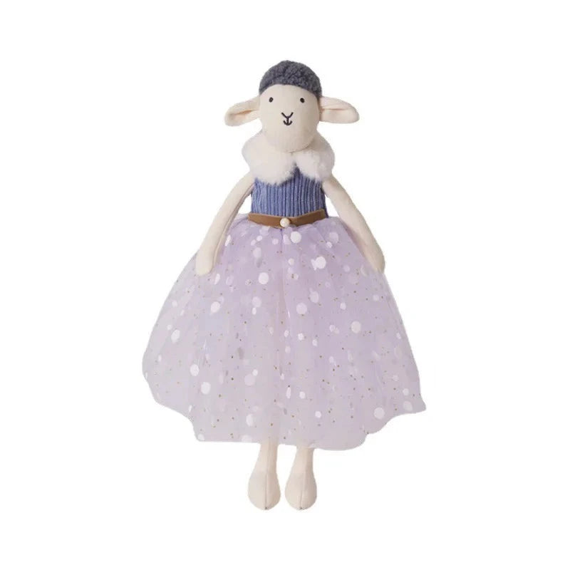 doudou peluche mouton en robe de fée blanche en tulle avec des rond brillant dessus, une ceinture marron à boucle perle blanche et haut bleu côtelé avec col en fourure blanche et un bonnet gris foncé tricoté  Image