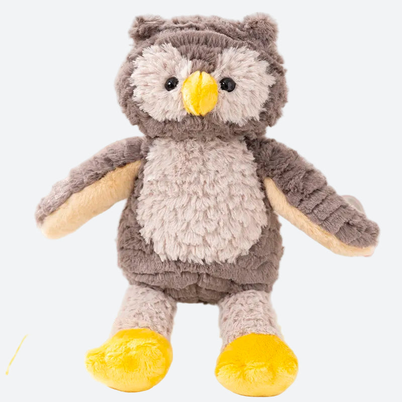 Peluche hiboux posée sur un livre claire sur une table ronde blanche