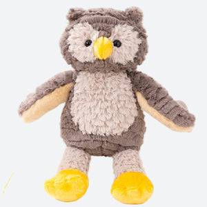 Peluche hiboux posée sur un livre claire sur une table ronde blanche