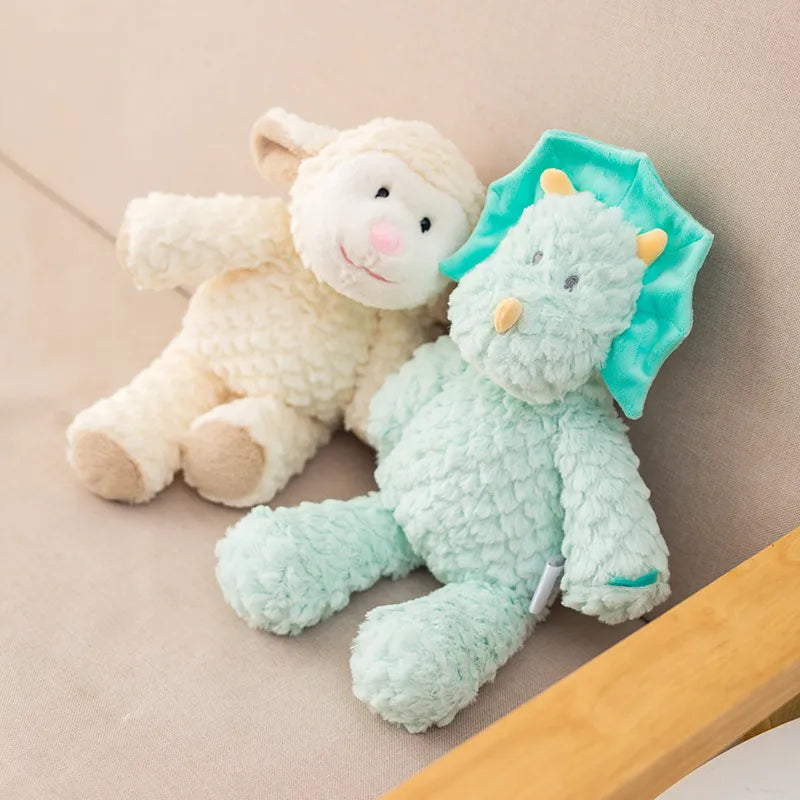 peluche mouton claire et dinosaure bleu mis en scène dans un fauteuil