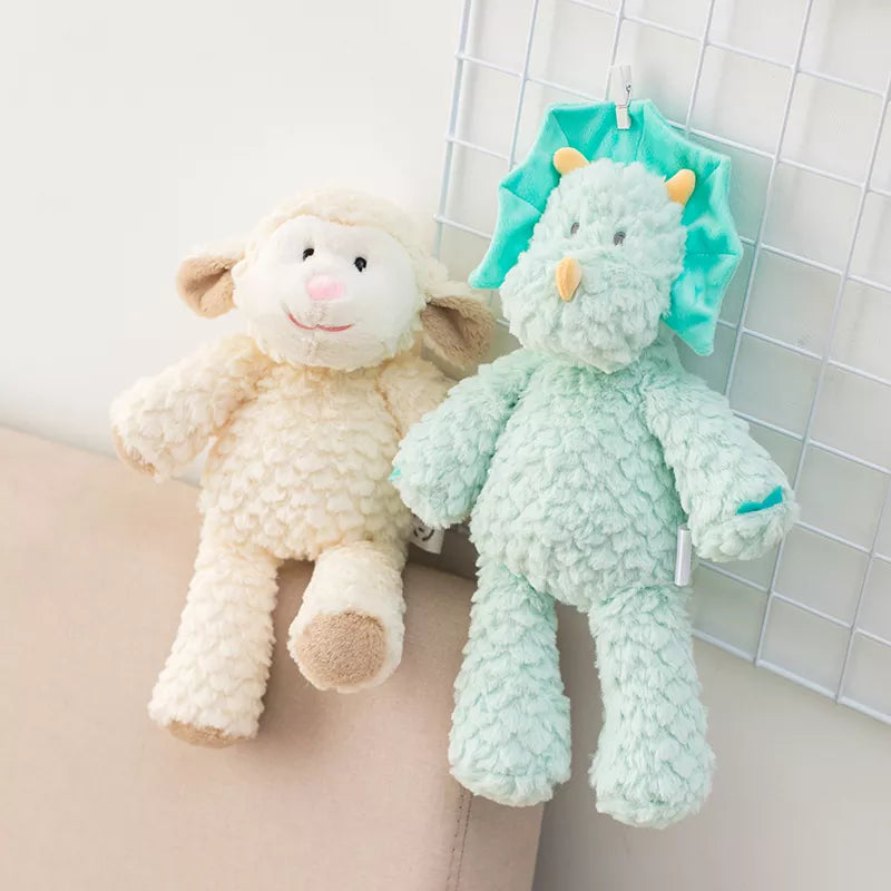peluche mouton claire et dinosaure bleu mis en scène sur un fauteuil et une grille métallique