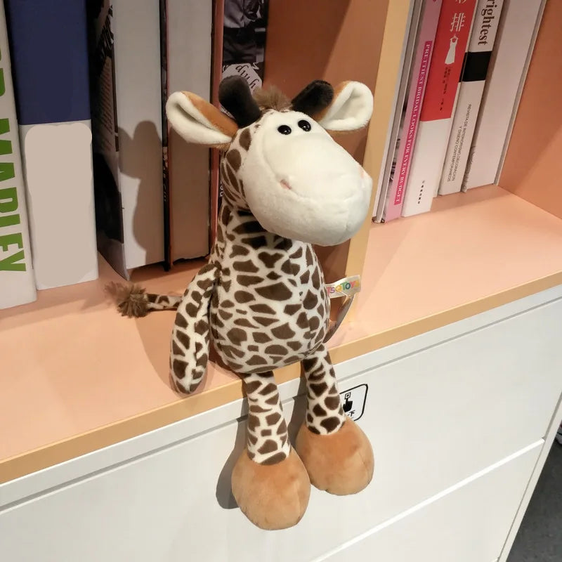 Peluche girafe - BASILE posé sur une étagère de bibliothèque photo de 3/4 gauche