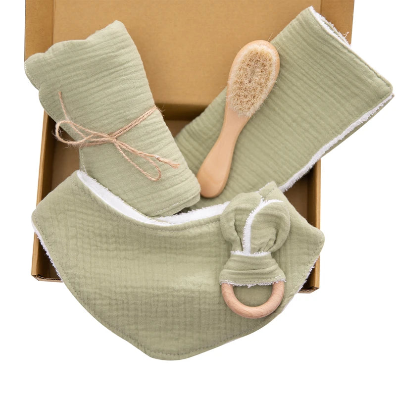 Coffret bébé - ALIX vert Bavoir en Gaze de Coton : Coloré d'un côté et en coton blanc de l'autre, absorbant et pratique. Hochet en Gaze de Coton avec Anneau de Bois : Doux et sécurisant, parfait pour les petites mains de bébé. Lange en Gaze de Coton : Polyvalent et utile pour diverses situations quotidiennes. Petit Essuie en Gaze de Coton : Coloré d'un côté et en coton blanc de l'autre, doux et absorbant. Brosse en Bois : 15 x 4 cm, douce pour le cuir chevelu délicat de bébé. Image
