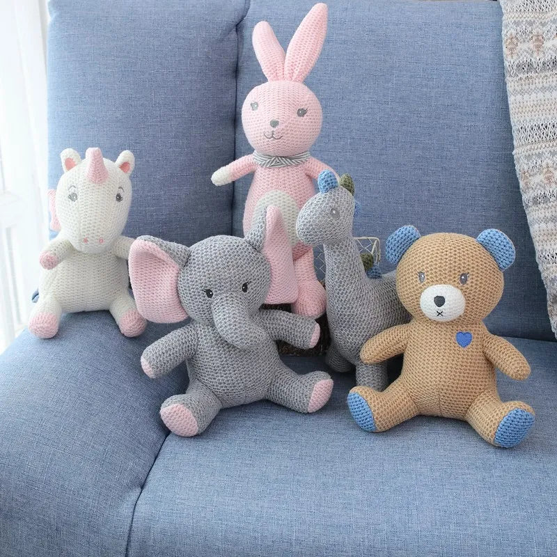 Les amis tricotés ; l’éléphant UGO, le lapin KILIAN, l’ours BILAL, la licorne JANICE, et la licorne MANOE sont regroupés sur un petit canapé bleu