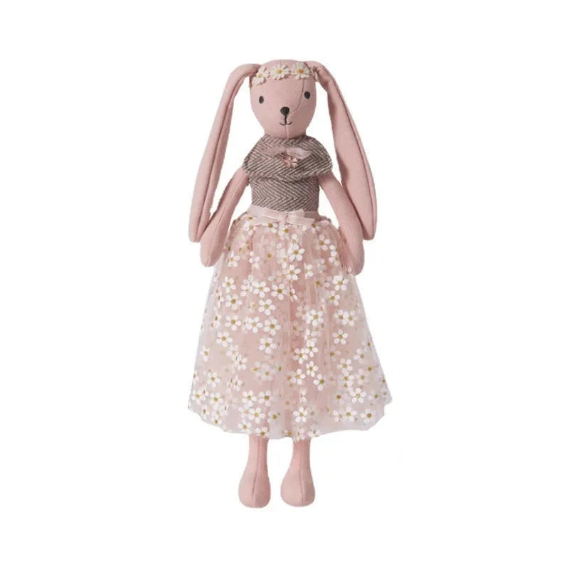 Doudou lapin robe à fleurs blanche, ceinture de satin nouée à la taille, haut de laine marron et blanche avec petite broche bijou et une couronne de fleurs sur la tête