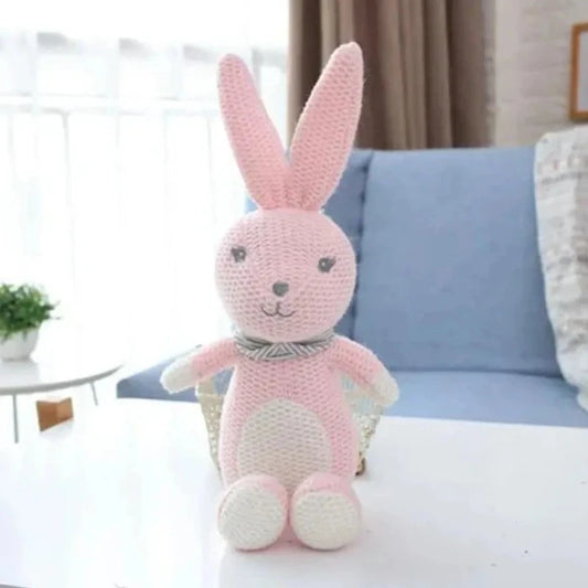 Plongez dans un monde de douceur avec la peluche lapin KILIAN. Mesurant 25 cm, cette adorable créature tricotée rose et blanche, agrémentée d'une écharpe grise à rayures, émerveillera votre enfant par sa tendresse et son charme féerique.