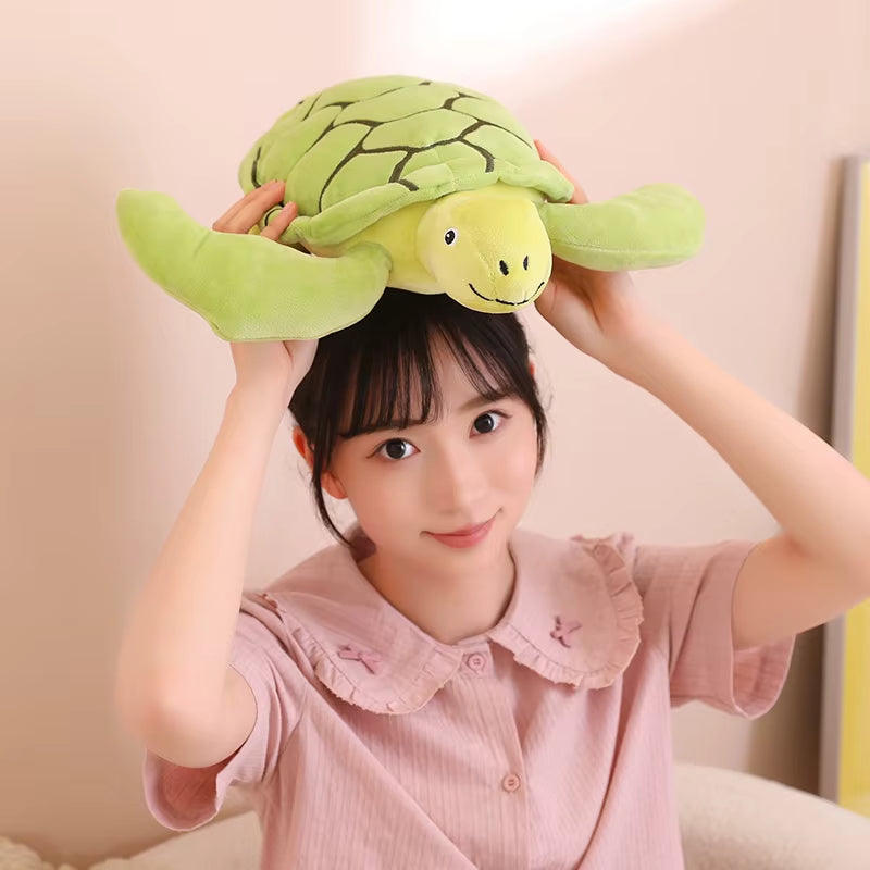 Une jeune femme qui tient sur la tete une peluche tortue verte - Sally