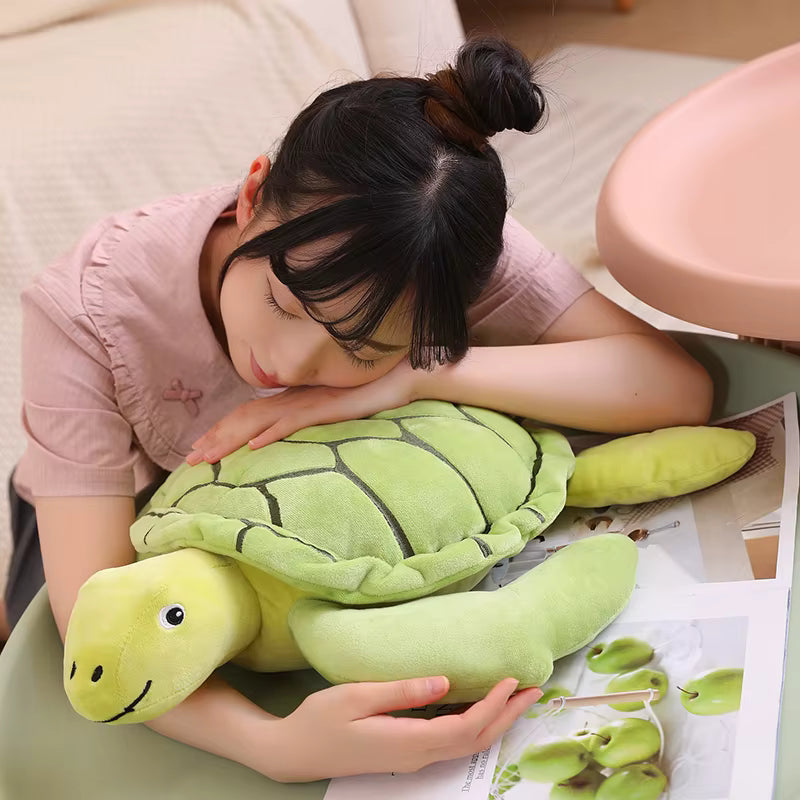 une fille qui est couchée sur la Peluche tortue verte - Sally Image