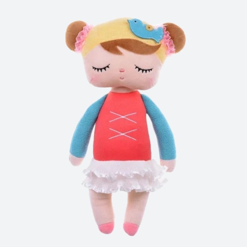 MARGE, le doudou fée Dolls de 34 cm, est une compagne féérique qui apportera réconfort et émerveillement à votre enfant. Avec ses détails soigneusement conçus, tels que ses deux chignons avec élastiques en dentelle rose, son bonnet jaune avec un oiseau bleu, son débardeur rouge lacé sur un t-shirt à manches longues bleues, sa jupe tutu en dentelle blanche et ses ballerines roses, elle inspire l'imagination et invite à des jeux magiques. Image