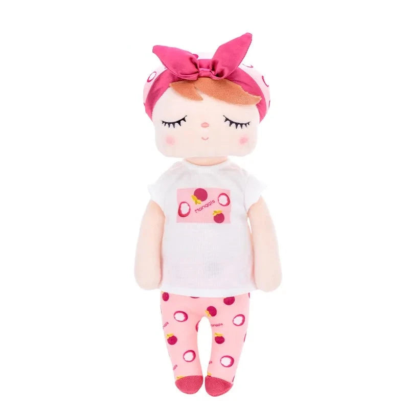 Rencontrez ARIA, le doudou fée dolls de 34 cm, avec ses cheveux roux et son bonnet blanc orné de motifs de fruits et d'un nœud pourpre. Son t-shirt blanc et son pantalon rose, tous deux décorés des mêmes fruits, ainsi que ses ballerines pourpres en font une compagne idéale pour des aventures féeriques.