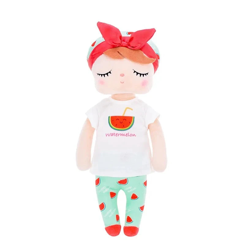 MASHA, la fée dolls de 34 cm, émerveille avec son t-shirt blanc orné d'un morceau de pastèque, son pantalon et son bonnet bleu ciel parsemés de morceaux de pastèque. Son bandeau à gros nœud et ses ballerines rouges ajoutent une touche de magie à son allure.