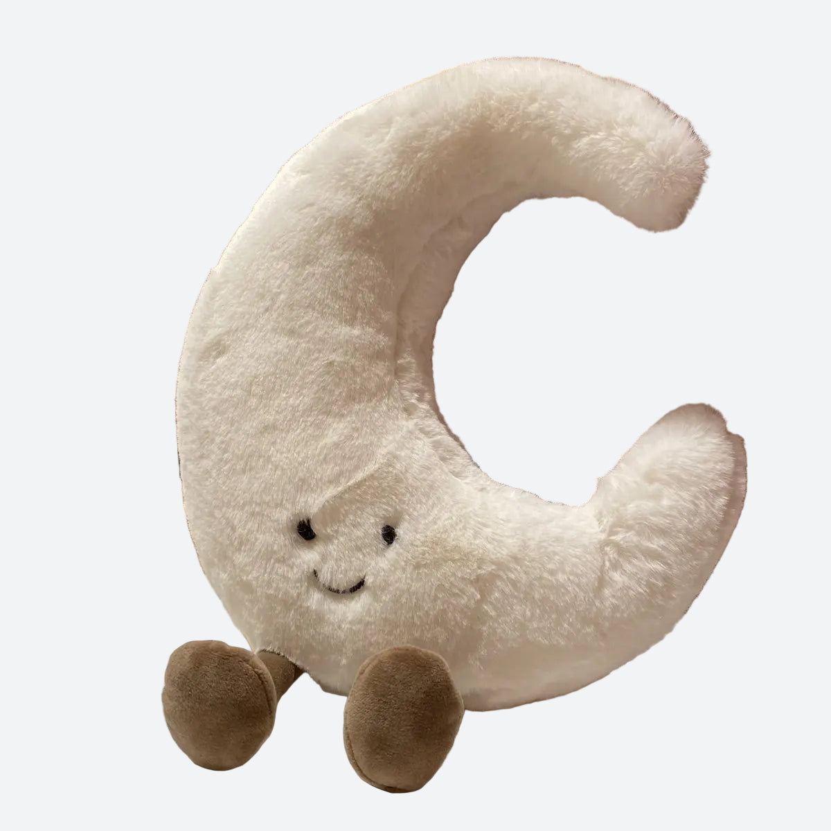 peluche lune blanche souriante posée sur une table blanche