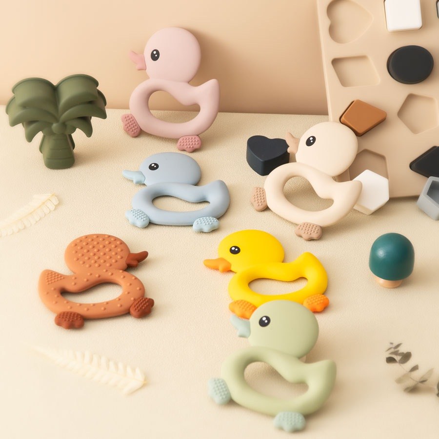 Anneaux de dentition canard posés parmi des jouets en bois Image