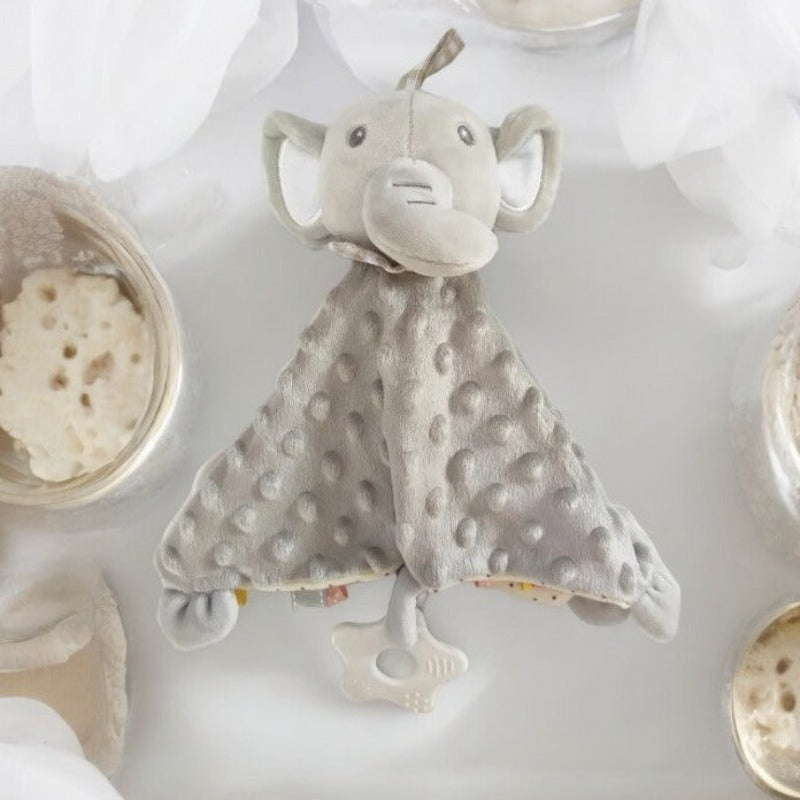 Le Doudou plat Éléphant DORKUF est entièrement gris, avec une tête en peluche et un corps plat en coton doudou tout doux. Son revers est délicatement imprimé à petits pois, ajoutant une touche ludique à son design. Doté d'un anneau de dentition blanc, d'étiquettes stimulantes et de petites pattes discrètes aux coins de son corps, ce doudou offre une expérience sensorielle riche pour le plaisir des tout-petits.