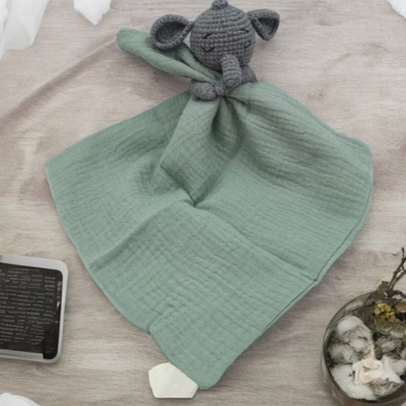 FABIO est un adorable doudou plat représentant un éléphant au crochet. Il tient un carré de tissu gaze de coton ou mouchoir entre ses pattes, offrant confort et réconfort à votre enfant. Disponible en plusieurs coloris de mouchoir : orange, vert et gris. VERT Image