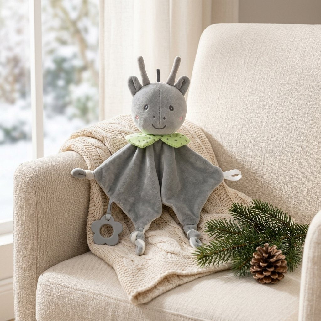 Doudou petit cerf posé dans un fauteuil avec un plaid