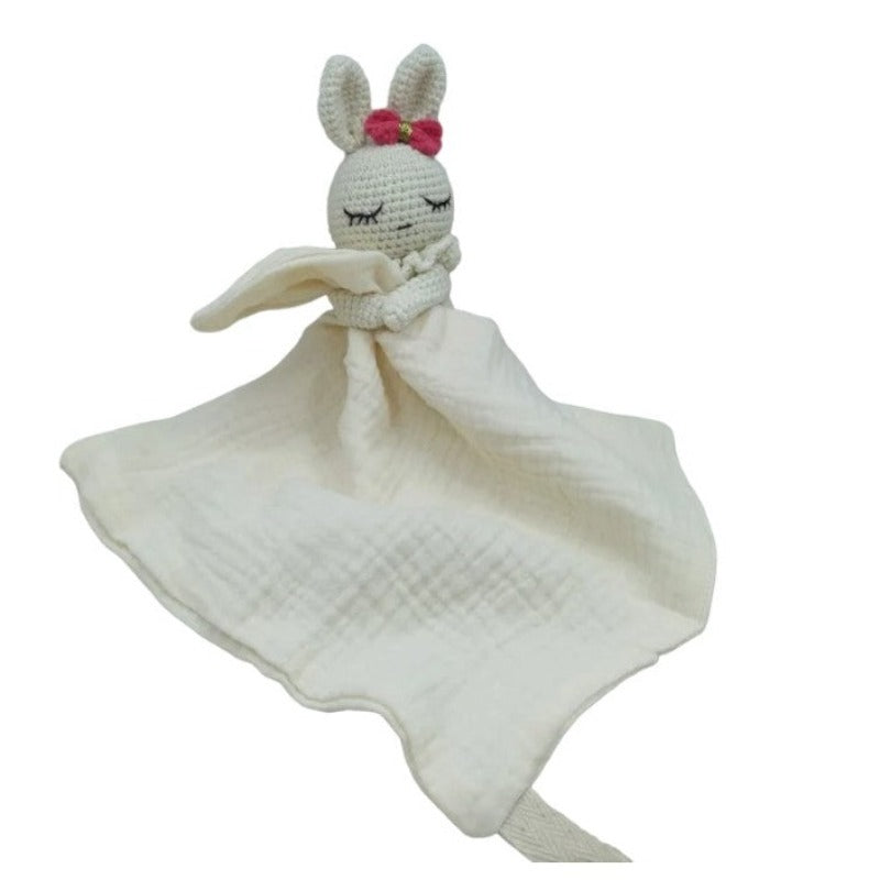 LIVIA est un adorable doudou plat représentant un lapin au crochet. Avec son noeud rose et doré sur la tête, il tient un mouchoir ou carré de gaze de coton entre ses pattes pour offrir douceur et réconfort à votre enfant. Disponible en trois coloris : Écru, Rose pâle et Vieux rose. ECRU