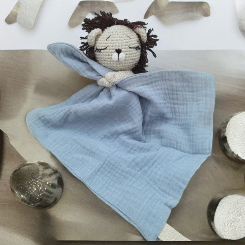 EROS est un adorable doudou plat représentant un lion au crochet. Il tient un mouchoir ou carré de gaze de coton entre ses pattes, offrant à votre enfant douceur et réconfort. Disponible en plusieurs coloris : Écru, Rose pâle, Bleu, Vieux rose et Vert. BLEU