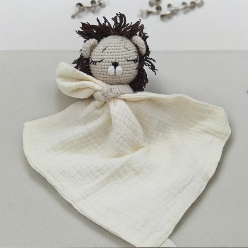 EROS est un adorable doudou plat représentant un lion au crochet. Il tient un mouchoir ou carré de gaze de coton entre ses pattes, offrant à votre enfant douceur et réconfort. Disponible en plusieurs coloris : Écru, Rose pâle, Bleu, Vieux rose et Vert. ECRU