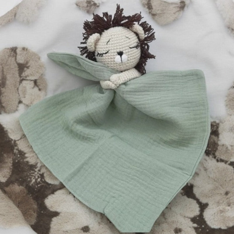 EROS est un adorable doudou plat représentant un lion au crochet. Il tient un mouchoir ou carré de gaze de coton entre ses pattes, offrant à votre enfant douceur et réconfort. Disponible en plusieurs coloris : Écru, Rose pâle, Bleu, Vieux rose et Vert. VERT