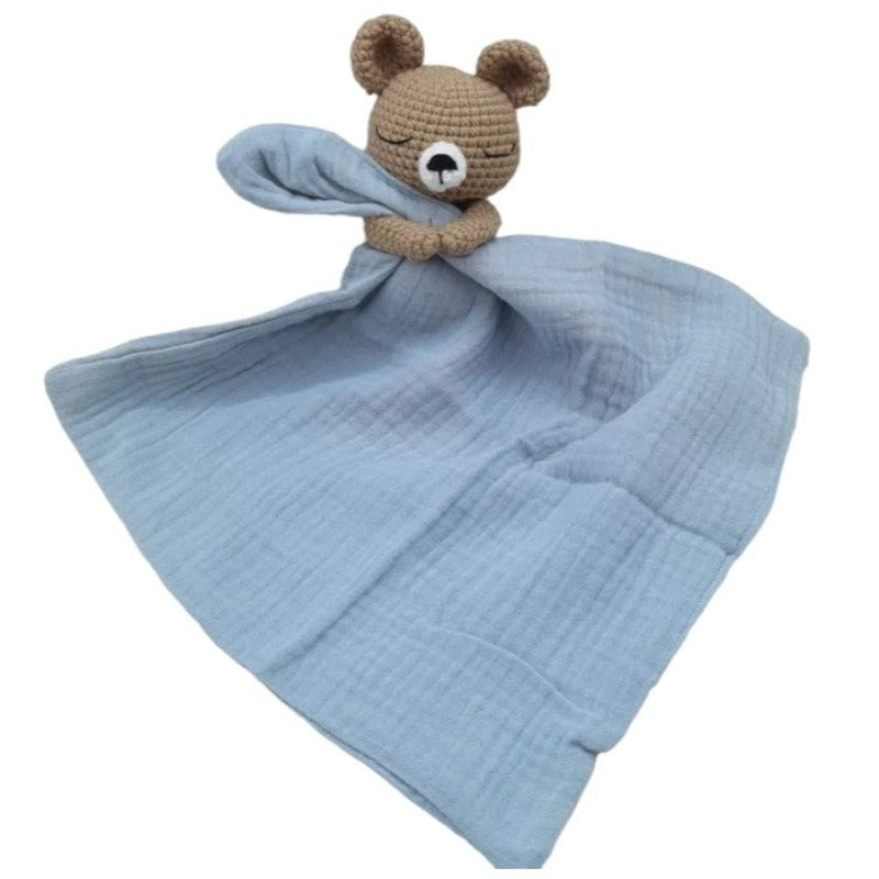 BARAT est un doudou plat représentant un adorable ours marron au crochet. Il tient un carré de tissu gaze de coton ou mouchoir entre ses pattes, pouvant également être utilisé comme attache tétine. Disponible avec 5 coloris de mouchoir : crème, vieux rose, rose pâle, écru et bleu. BLEU