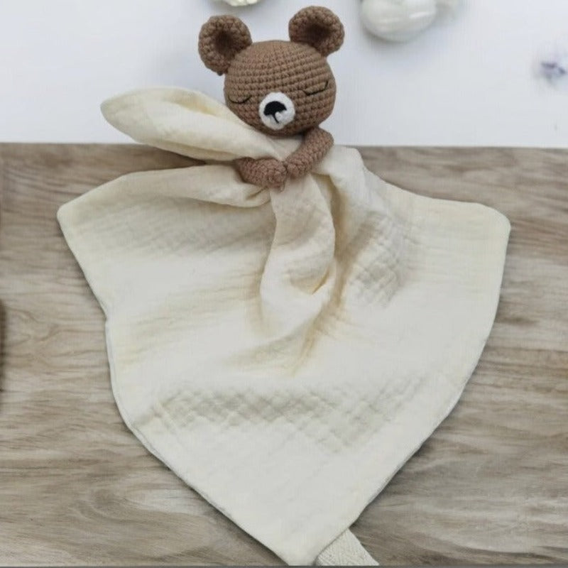 BARAT est un doudou plat représentant un adorable ours marron au crochet. Il tient un carré de tissu gaze de coton ou mouchoir entre ses pattes, pouvant également être utilisé comme attache tétine. Disponible avec 5 coloris de mouchoir : crème, vieux rose, rose pâle, écru et bleu. ECRU