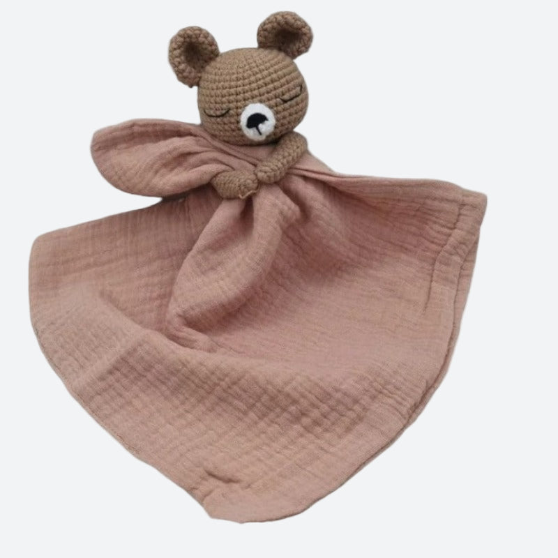 BARAT est un doudou plat représentant un adorable ours marron au crochet. Il tient un carré de tissu gaze de coton ou mouchoir entre ses pattes, pouvant également être utilisé comme attache tétine. Disponible avec 5 coloris de mouchoir : crème, vieux rose, rose pâle, écru et bleu.  VIEUX ROSE