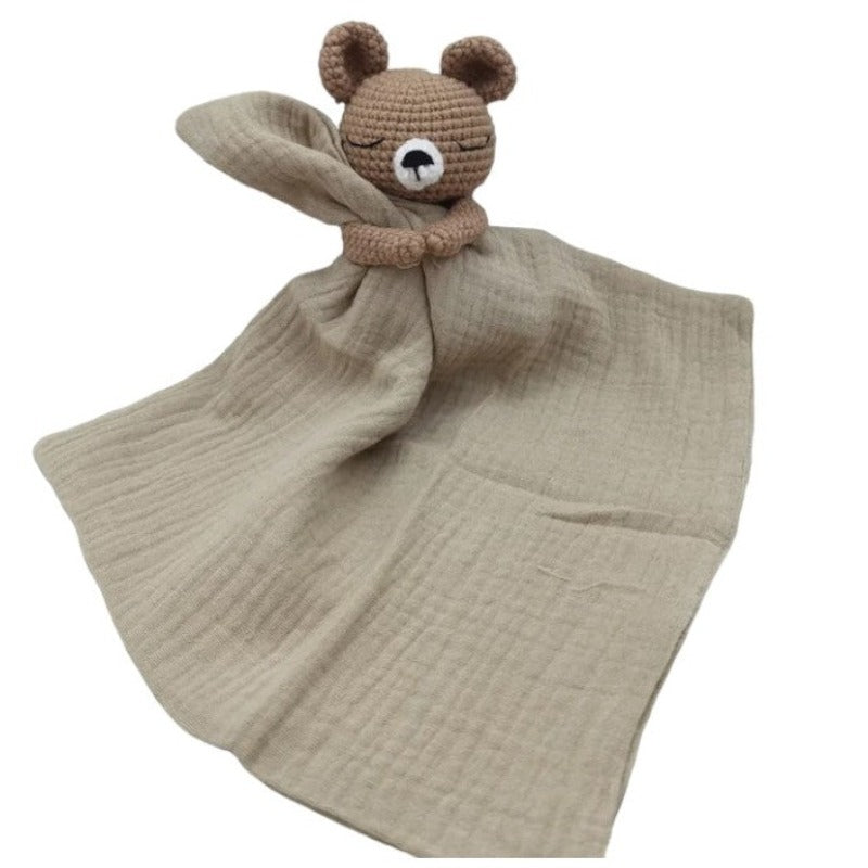 BARAT est un doudou plat représentant un adorable ours marron au crochet. Il tient un carré de tissu gaze de coton ou mouchoir entre ses pattes, pouvant également être utilisé comme attache tétine. Disponible avec 5 coloris de mouchoir : crème, vieux rose, rose pâle, écru et bleu. CREME