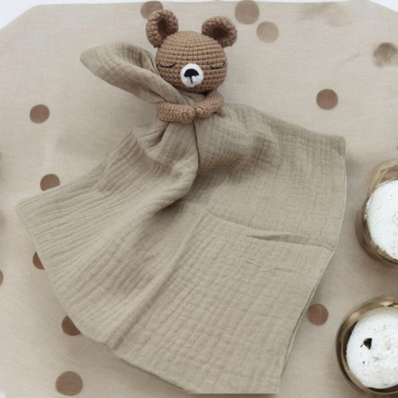 BARAT est un doudou plat représentant un adorable ours marron au crochet. Il tient un carré de tissu gaze de coton ou mouchoir entre ses pattes, pouvant également être utilisé comme attache tétine. Disponible avec 5 coloris de mouchoir : crème, vieux rose, rose pâle, écru et bleu. CREME