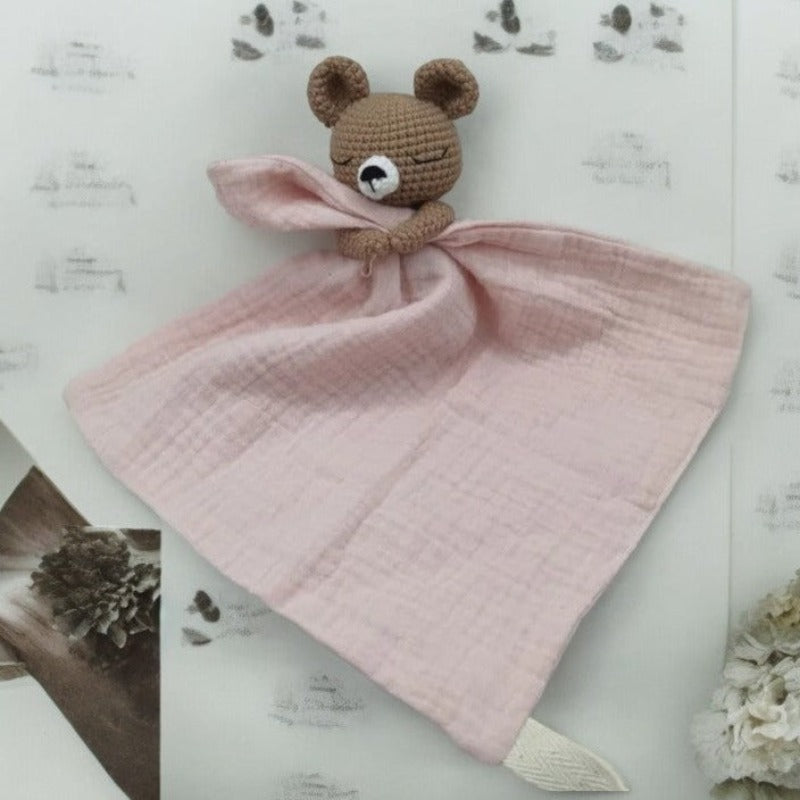 BARAT est un doudou plat représentant un adorable ours marron au crochet. Il tient un carré de tissu gaze de coton ou mouchoir entre ses pattes, pouvant également être utilisé comme attache tétine. Disponible avec 5 coloris de mouchoir : crème, vieux rose, rose pâle, écru et bleu. ROSE PALE