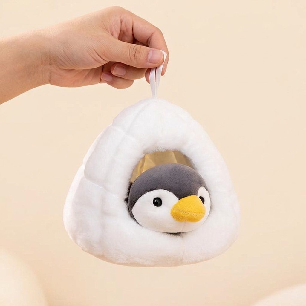 Main tenant la peluche igloo par sa boucle de suspension