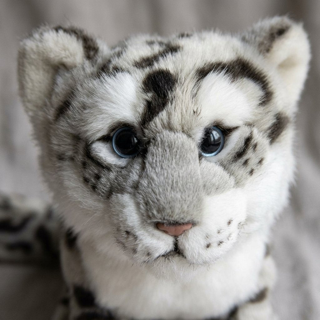 Gros plan sur la tête et les yeux bleus de la peluche léopard des neiges