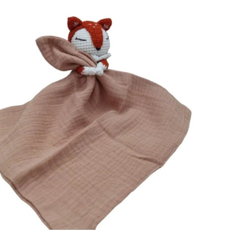 VIGOT est un doudou plat représentant un renard au crochet, de couleur orange et blanc, tenant un carré de tissu gaze de coton ou mouchoir entre ses pattes. Disponible avec 4 coloris de mouchoir : vieux rose, écru, bleu et vert. VIEUX ROSE