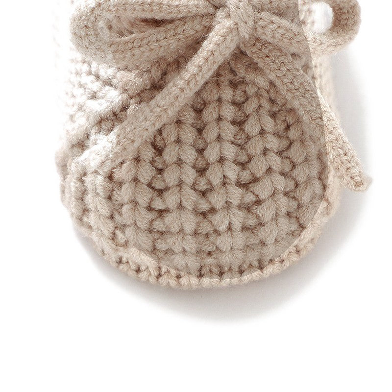 Mailles et lacet noué des chaussons en tricot