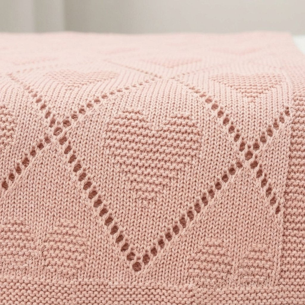 Détail du tricot ajouré à losanges et cœurs de la couverture